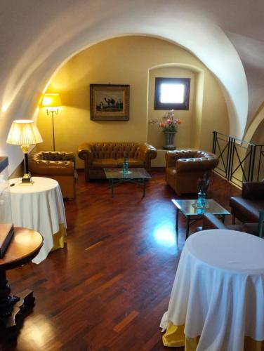 a living room with couches and tables in a room at Hotel Foresteria Baglio Della Luna in San Leone