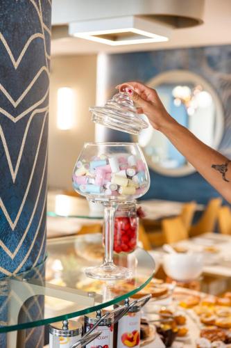 a person is putting medicines in a glass jar at Hotel Villa Paola in Rimini