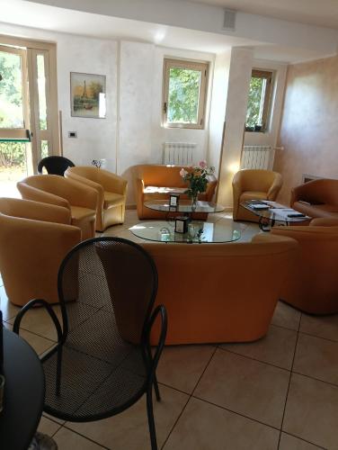 a waiting room with couches and a table and chairs at Hotel Aquila in Scoppito
