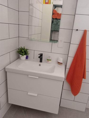 a white bathroom with a sink and a mirror at Apartment Sun Kapparis in Paralimni