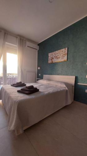 a large bed in a bedroom with a green wall at La Pilozza Guest Rooms in Gallipoli