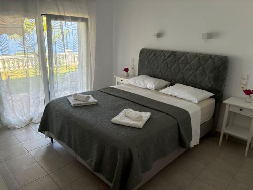 a bedroom with a bed with two towels on it at Syvota Sunset Apartments in Perdika