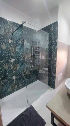 a bathroom with a shower with a glass wall at La Pilozza Guest Rooms in Gallipoli