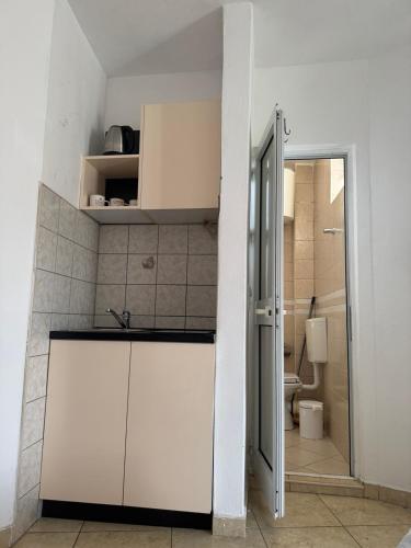a white kitchen with a sink and a toilet at Best Apartments in Ulcinj