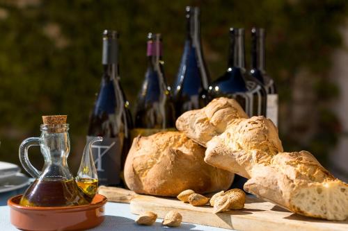 a table topped with bread and bottles of wine at Casa Rural Boutique - Ca Bolo in Pinell de Bray