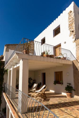 a white house with two chairs and a balcony at Casa Rural Boutique - Ca Bolo in Pinell de Bray