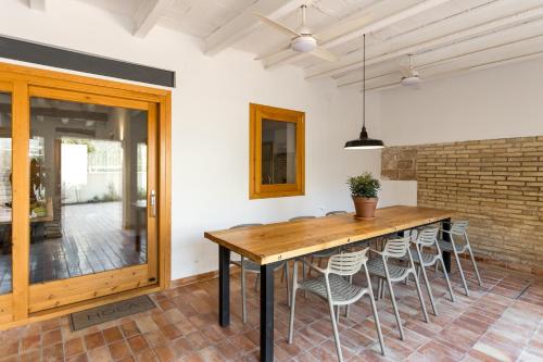 a dining room with a wooden table and chairs at Casa Rural Boutique - Ca Bolo in Pinell de Bray
