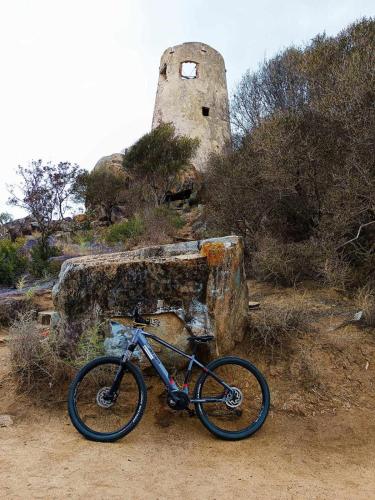a bike is parked next to a stone building at La Piccola Corte da Anita in Tortolì