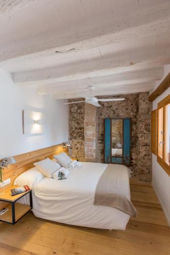 a bedroom with a large bed and a stone wall at Casa Rural Boutique - Ca Bolo in Pinell de Bray