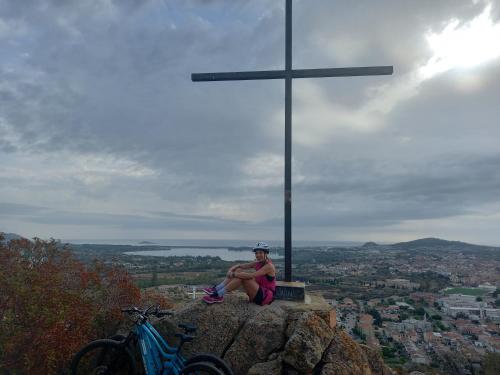 a woman sitting on a rock next to a cross at La Piccola Corte da Anita in Tortolì