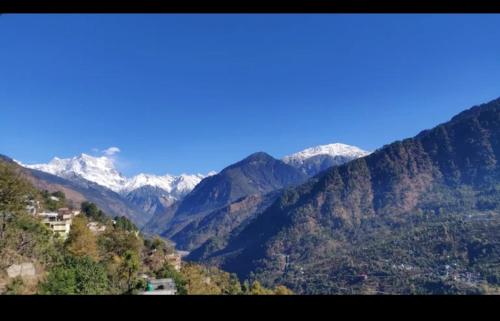 a view of a mountain range with snow covered mountains at Kedar palace in Ukhimath