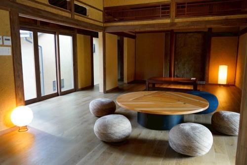 a room with a table and some stools at 囲み宿 こわね in Tonosho