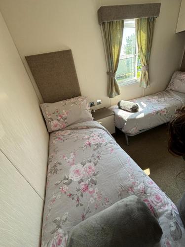 a small bedroom with two beds and a window at DaisyChain Getaways The perfect place to Stay Play and Getaway in East Mersea