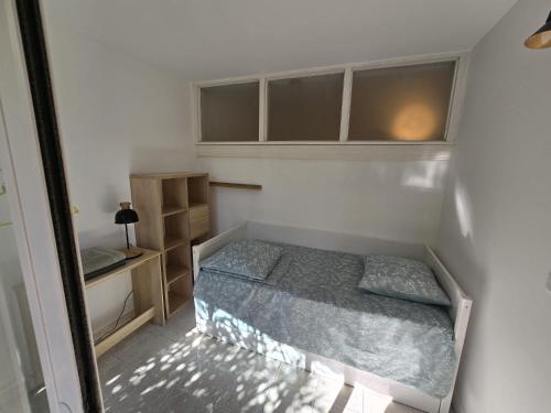 une petite chambre avec un lit et un bureau dans l'établissement Grand Soleil Vélodrome- Marseille, à Marseille