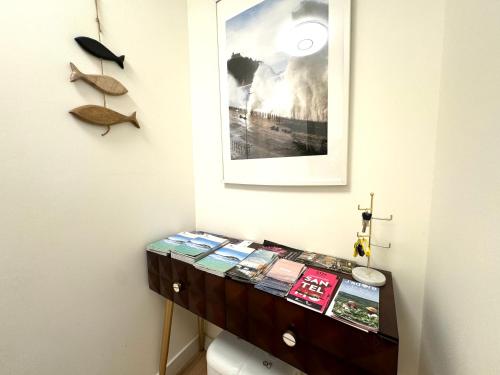 a table with books on it next to a wall at Paradise Luxurious apartment, 3 double rooms for 6 guests, 4 beds, terrace, jacuzzi, free parking, new in Donostia-San Sebastián