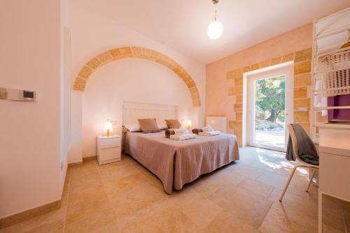 a bedroom with a bed and a large window at Masseria Romanelli Noya Agriturismo in Monopoli