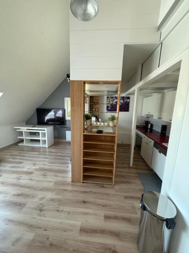 a living room with a staircase and a kitchen at Pretty little house Jolie petite maison in Rueil-Malmaison