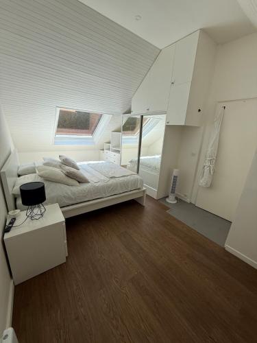 a large white bedroom with a bed and a window at Pretty little house Jolie petite maison in Rueil-Malmaison