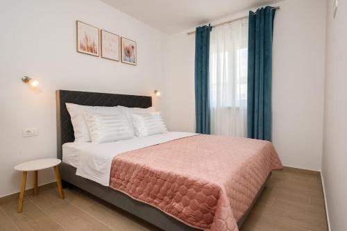 a bedroom with a large bed with a pink blanket at ColorsVibe Apartment in Trogir
