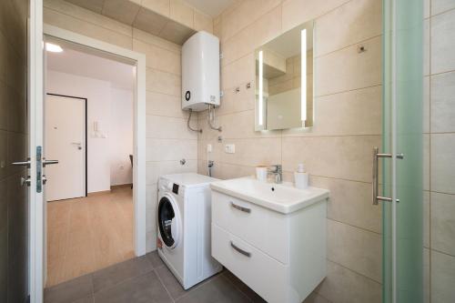 a bathroom with a washing machine and a sink at ColorsVibe Apartment in Trogir