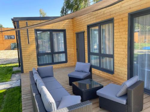 eine Terrasse mit einem Sofa, 2 Stühlen und einem Tisch in der Unterkunft Rajski Hel in Hel