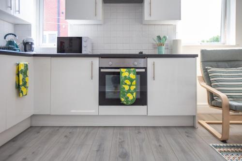a kitchen with white cabinets and an oven at Lytham St Annes Luxury Apartment - No 1 Tides Reach in Lytham St Annes