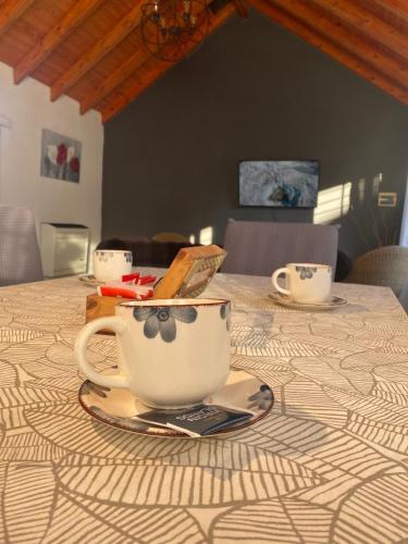 a table with a coffee cup on a plate on it at Chalet Liwen in San Martín de los Andes