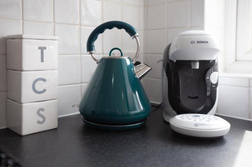 a green kettle on a counter next to a blender at Lytham St Annes Luxury Apartment - No 1 Tides Reach in Lytham St Annes