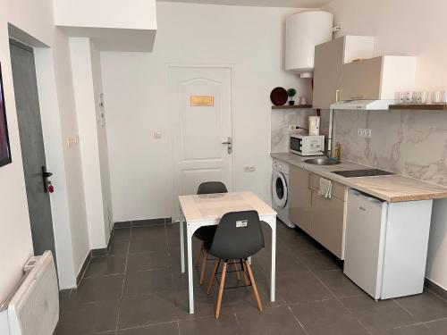une petite cuisine avec une table et des chaises. dans l'établissement Studio Nr2 Centre Ville, à Tarbes