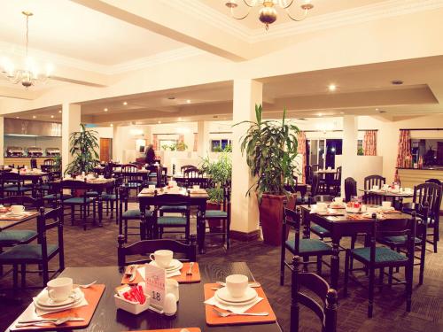 松鎮的住宿－Premier Splendid Inn Pinetown，餐厅内带桌椅的用餐室