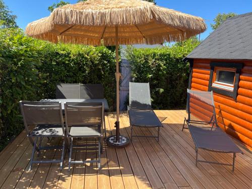 une table et des chaises sous un parasol sur une terrasse dans l'établissement logement insolite KOTA, à Commequiers