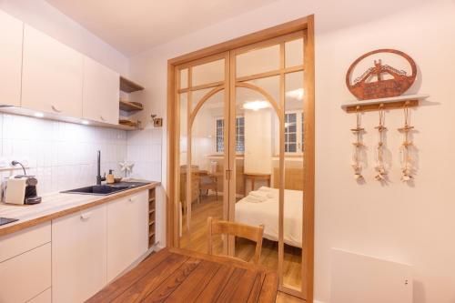 une cuisine avec une porte menant à une salle à manger dans l'établissement La p'tite barque des remparts Mer, à Saint-Malo