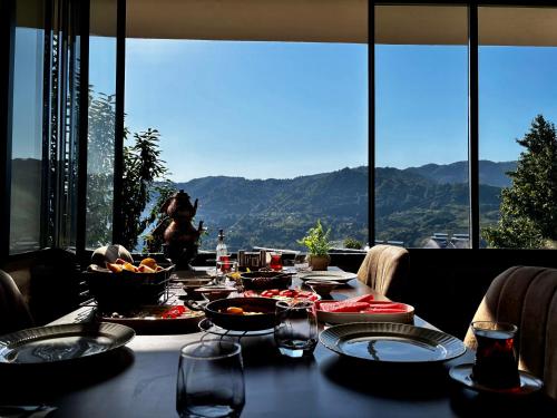 a table with food on it with a view of mountains at Yaylamisun Suite Otel in Çamlıhemşin