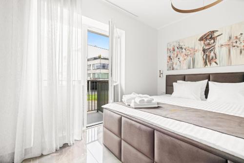 a bedroom with a large bed and a window at F-Apartments - Emperor Size Bed, City Center, Contactless in Tartu