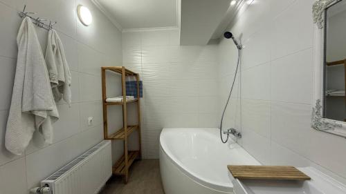a white bathroom with a tub and a sink at Apartament spațios, 2 dormitoare, confortabil in Chişinău