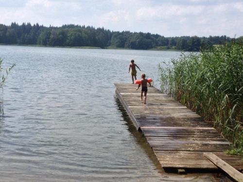 two children walking on a dock on a lake at Große Wohnung mit Loggia in Templin
