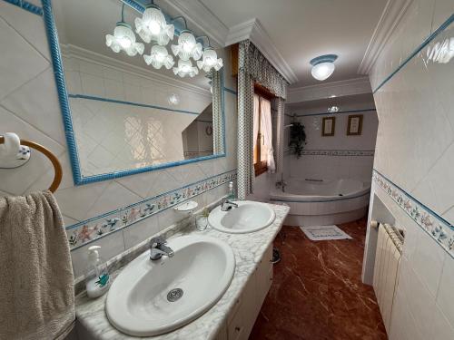 a bathroom with two sinks and a mirror and a tub at Casa Rural La Petita in Tibi