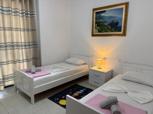 two twin beds in a room with a window at Marinela Apartment 2 in Tirana