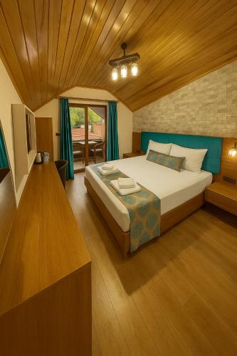 a bedroom with a large bed and a table at Centro Park Hotel in Uzungöl