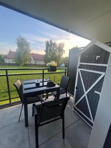 un patio con tavolo e sedie su un balcone di Czapla Siwa Sole Mare a Kąty Rybackie