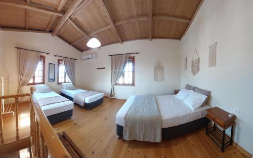 1 dormitorio con 2 camas en una habitación con suelo de madera en Casa Cretese Chania, en Tsikalariá