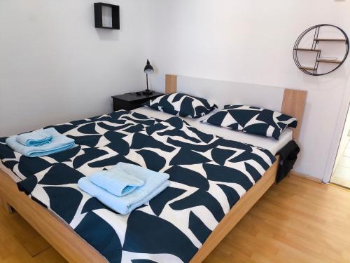 a bedroom with a black and white bed with towels on it at Zusy in Orebić
