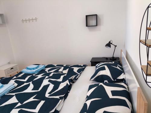 a bedroom with a bed with a black and white comforter at Zusy in Orebić