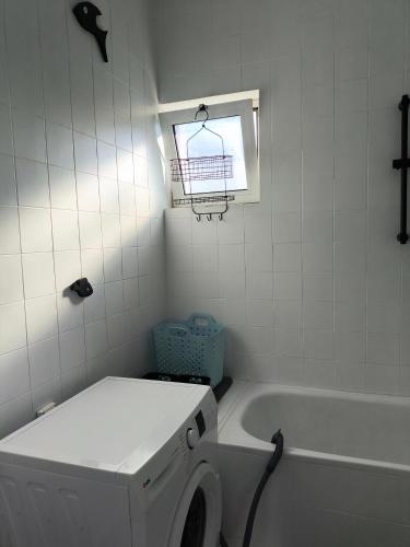 a bathroom with a washing machine and a bath tub at Zusy in Orebić