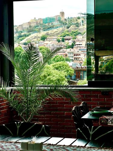 a plant in a room with a view of a city at Hotel New Terrace in Tbilisi City