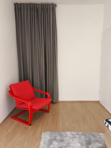 a red chair in a room with a curtain at Zusy in Orebić