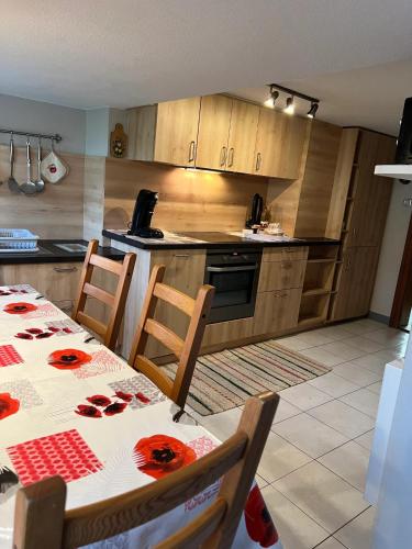 - une cuisine avec une table et des roses rouges dans l'établissement Maison accueillante dans Wingersheim-les-Quatre-Bans avec terrasse., à Wingersheim