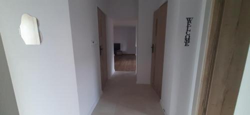 a hallway with white walls and a hallway with doors at Apartamenty Kraków-Bielany in Kraków