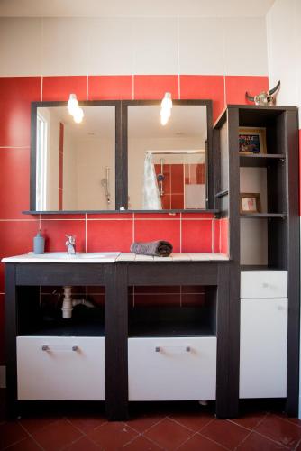 une salle de bain avec un lavabo et un miroir dans l'établissement Chez Les Artistes Jacuzzi terrasse et billard, à Carcassonne