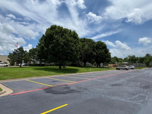 an empty parking lot with a car parked in it at Americas Best Value Inn and Suites Ada in Ada